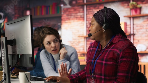 Bilde på lerret Call center agent in noisy office asking coworker to lower voice while providing guidance to customers