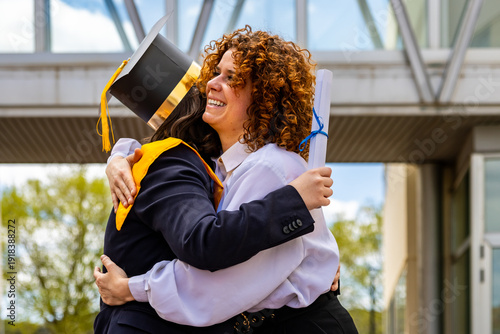 Two happy women hugging and celebrating graduation from university