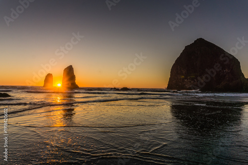Foto The sun is setting over the ocean, casting a warm glow on the water