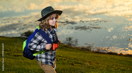 Child tourists with backpacks. Adventure, travel, and tourism concept. Kid walking with backpacks on nature. Little explorer on trip.