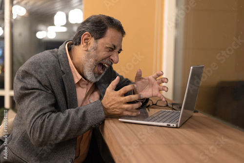 Tablou pe pânză Indian angry senior man in use laptop work throw up hands concerned about problems