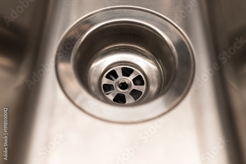 Close-up of Modern Stainless Steel Kitchen Sink Drain Hole. plumbing, interior design, home maintenance, and kitchenware products.