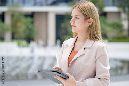 Wallpaper Mural Young caucasian businesswoman writing on digital tablet in city, professional business woman concentrating and note on tablet in business district, employee in modern city, planning marketing. Torontodigital.ca