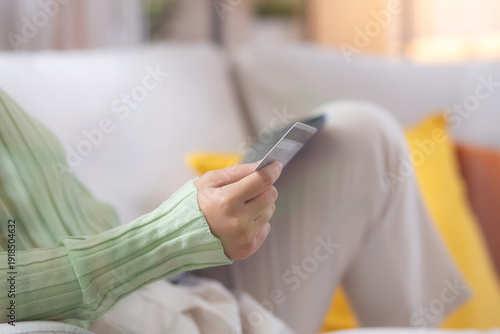 Wallpaper Mural Young asian woman sitting on sofa using tablet computer shopping online with credit card buying to internet while cheerful, female payment with business, purchase and payment, business and finance. Torontodigital.ca