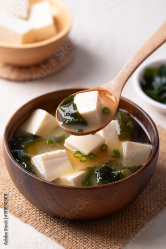 Φωτογραφία Healthy Japanese miso soup with soft tofu and seaweed in a wooden bowl being sco