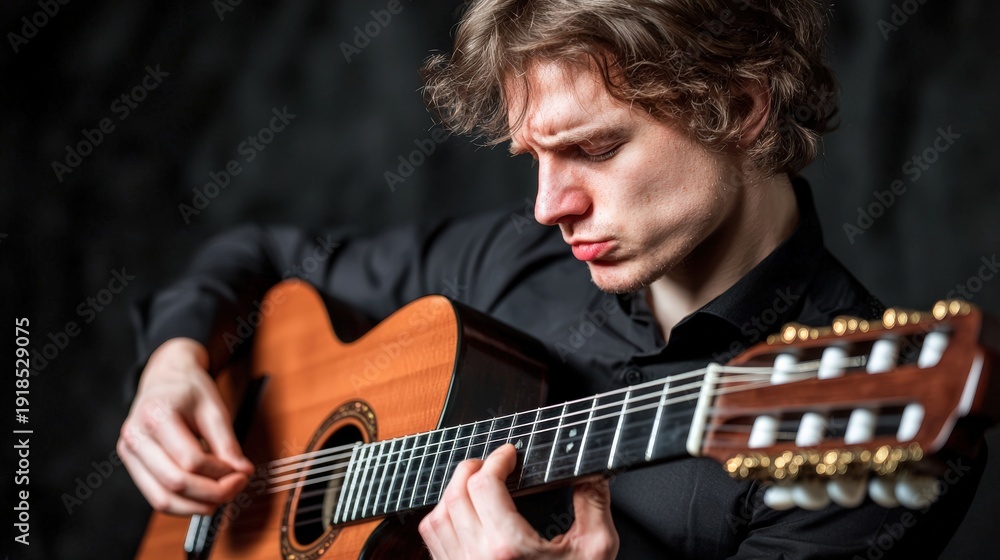 Obraz premium Close-up of a musician playing a guitar with passionate expression: A detailed shot of a musician s hands strumming a guitar, with the artist s face in the background expressing deep emotion,