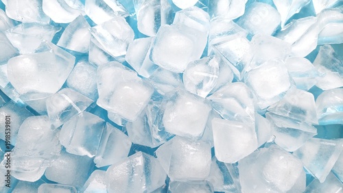 Top view of fresh ice cubes on blue background. Crystal clear ice cube texture with cold feeling. Crushed ice pieces creating a cool frozen background.