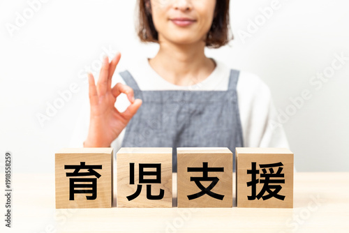 「育児支援」と書かれたブロックとエプロン姿の女性　