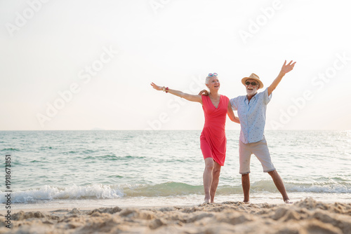 Happy senior couple using smart phone together on the beach