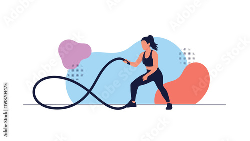 Determined athletic woman in sportswear performing a high intensity workout with heavy battle ropes for strength and cardiovascular fitness.