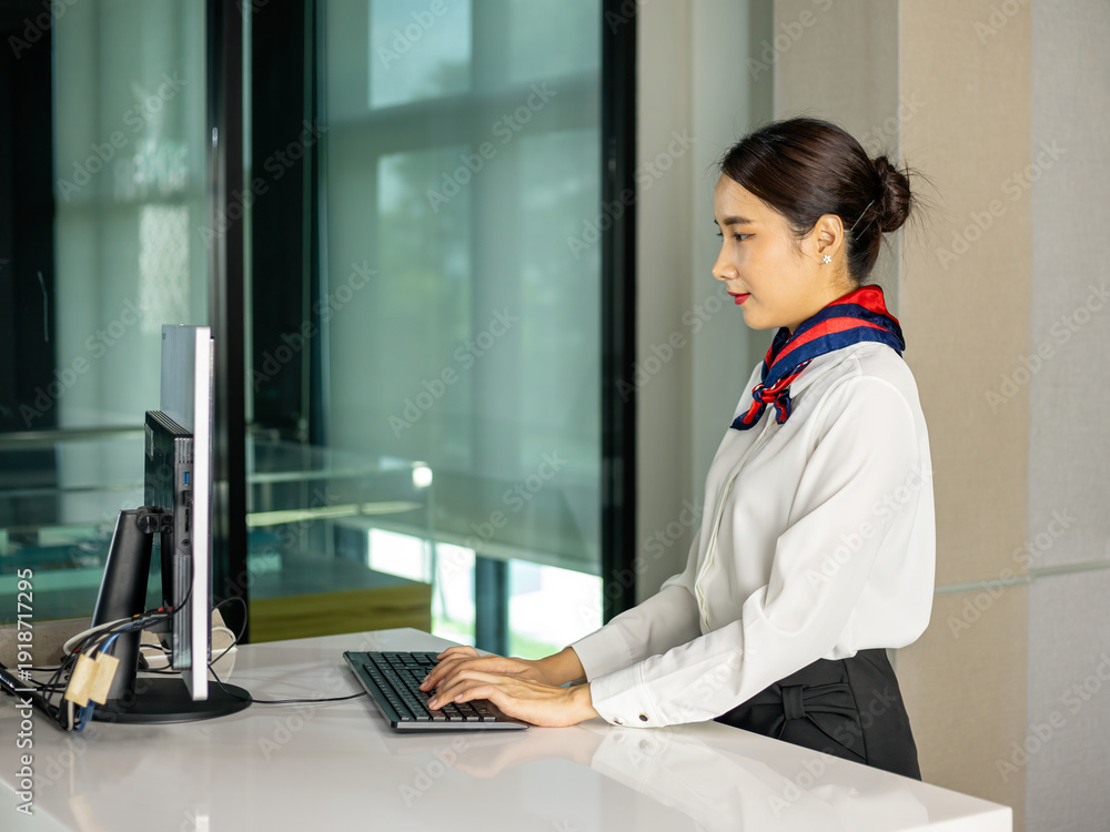 custom made wallpaper toronto digitalProfessional air hostess working at desktop computer in check-in counter, typing on keyboard, corporate administration, customer service, workplace productivity concept