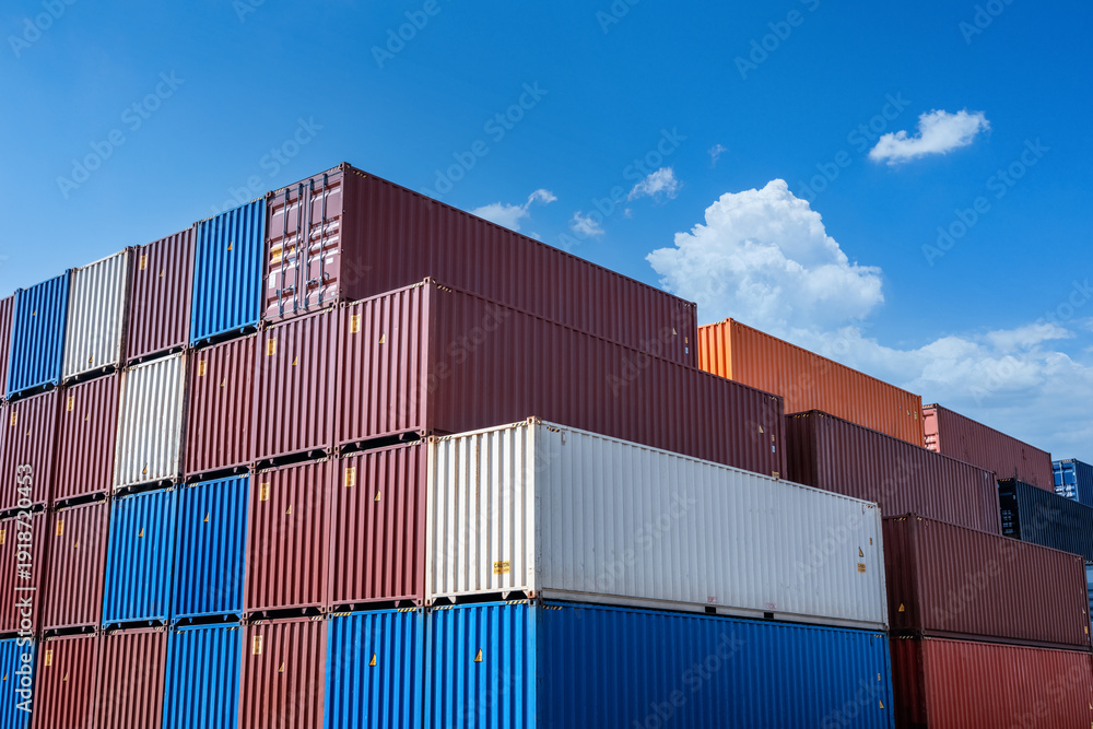 Fototapeta premium Stacked Shipping Containers Under Blue Sky