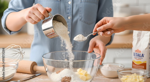 Two people collaborating in the kitchen by adding dry ingredients for baking a cake