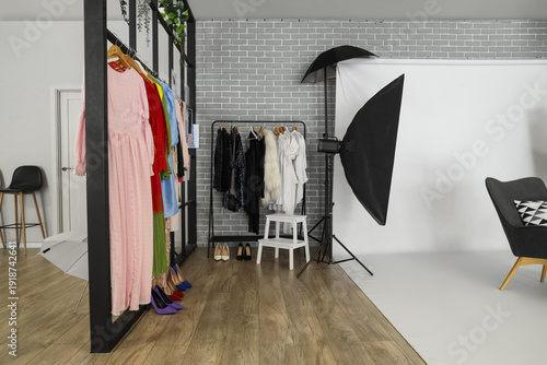 Photography Interior of photo studio with professional equipment, clothes and folding screen