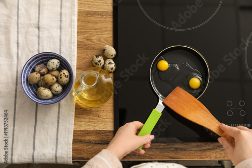 Woman frying quail eggs on ...