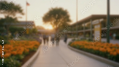 Wallpaper Mural Blurred background of Main exit gate with wide pedestrian pathway, landscaped flower beds and clear “Thank You for Visiting” signage above, souvenir bags in visitors’ hands, Sunset, Warm orange glow. Torontodigital.ca