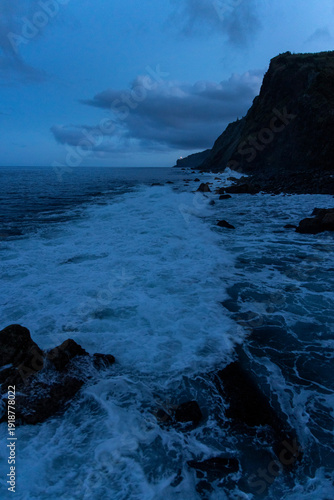 The ocean is calm and the sky is dark