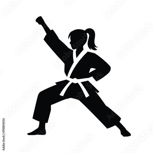 Silhouette of a woman practicing a karate pose with raised fist