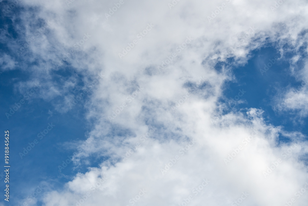 Obraz premium Bright white cumulus clouds spread across a clear blue sky