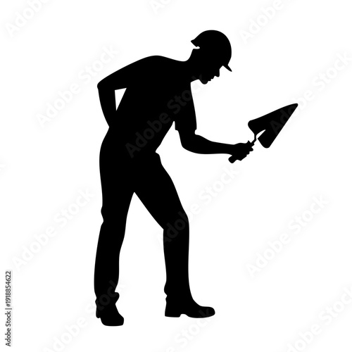 Construction worker applying plaster with trowel on wall from side view