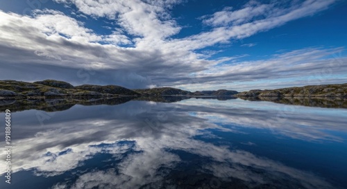 Lake reflects sky; rocky shore in distance