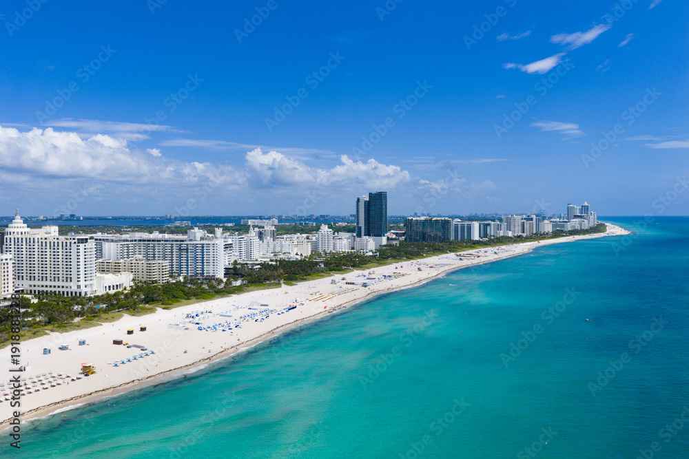 Obraz premium Drone aerial view of Miamis sandy beach. Miami coastline. Wide drone shot of Miami Beach and ocean waves. Miami Beach from above. Oceanfront Miami resorts by drone.