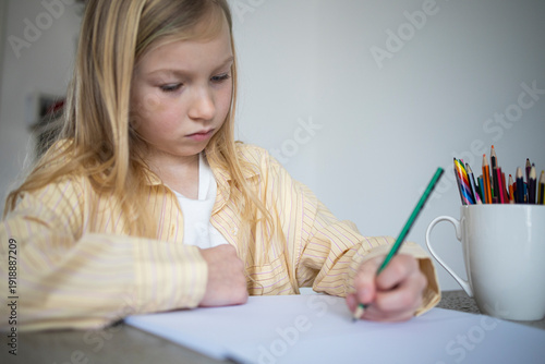 Over Shoulder View of Young Girl Drawing with Pencil at Home