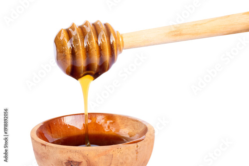 honey dripping from a wooden dipper isolated on white background