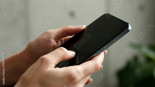 Woman holding a black smartphone device.