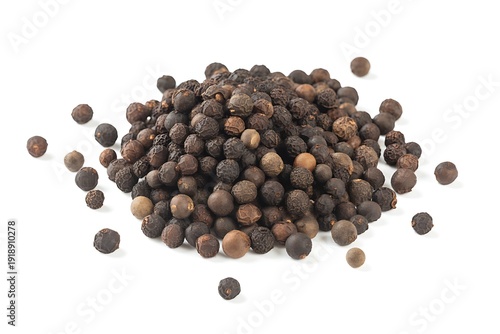 Pile of black peppercorns on white background for culinary use