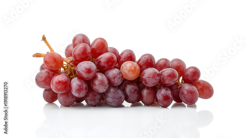 A lush cluster of red seedless grapes is artfully arranged against seamless, brilliant white background