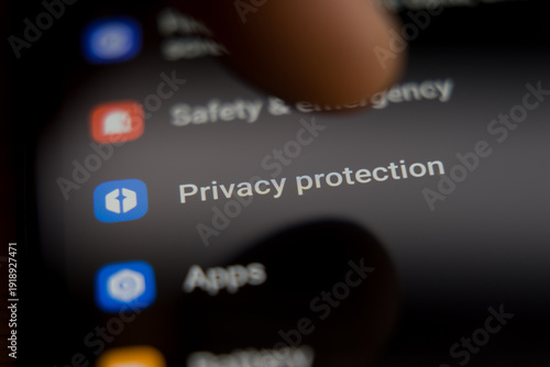 Close up of a smartphone screen showing the privacy protection settings menu with a finger ready to tap the icon, representing mobile data security, user privacy controls, and digital safety.