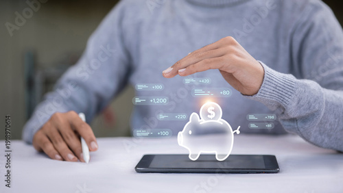 Man protecting digital piggy bank icon on tablet for financial saving concept