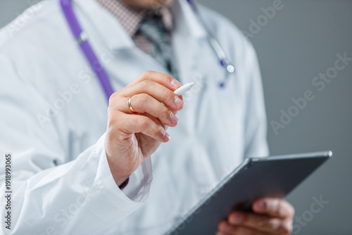 Bilde på lerret Close-up of doctor with stylus and tablet updating electronic medical records in
