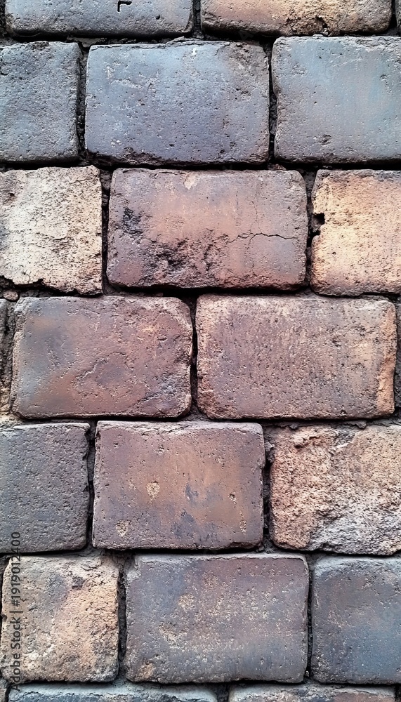 Fototapeta premium Aged Brick Facade in Red, Brown, Beige, and Grey Hues, Showcasing Urban Traditional Textures