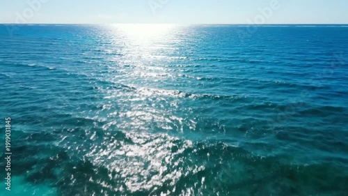 Serene Ocean Waves with Sunlight Reflection.