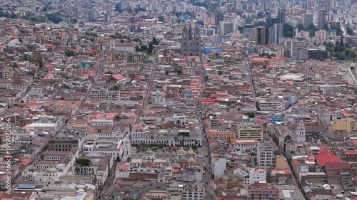 Drone advances over Quito city revealing dense urban grid and Basilica del Voto Nacional in Ecuador capital
