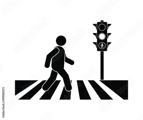 Silhouette of a person walking across a pedestrian crossing with a traffic signal showing the pedestrian walking icon