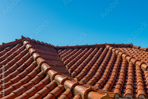 Czerwone dachówki na tle błękitnego nieba w śródziemnomorskim stylu