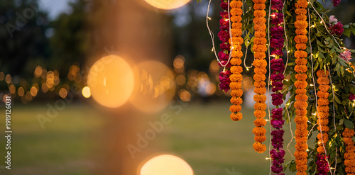 Traditional floral marigold garland decoration for Indian wedding ceremony on blur background. Banner template for autumn celebration festival or toran Indian traditional Diwali, Day of dead, wedding 