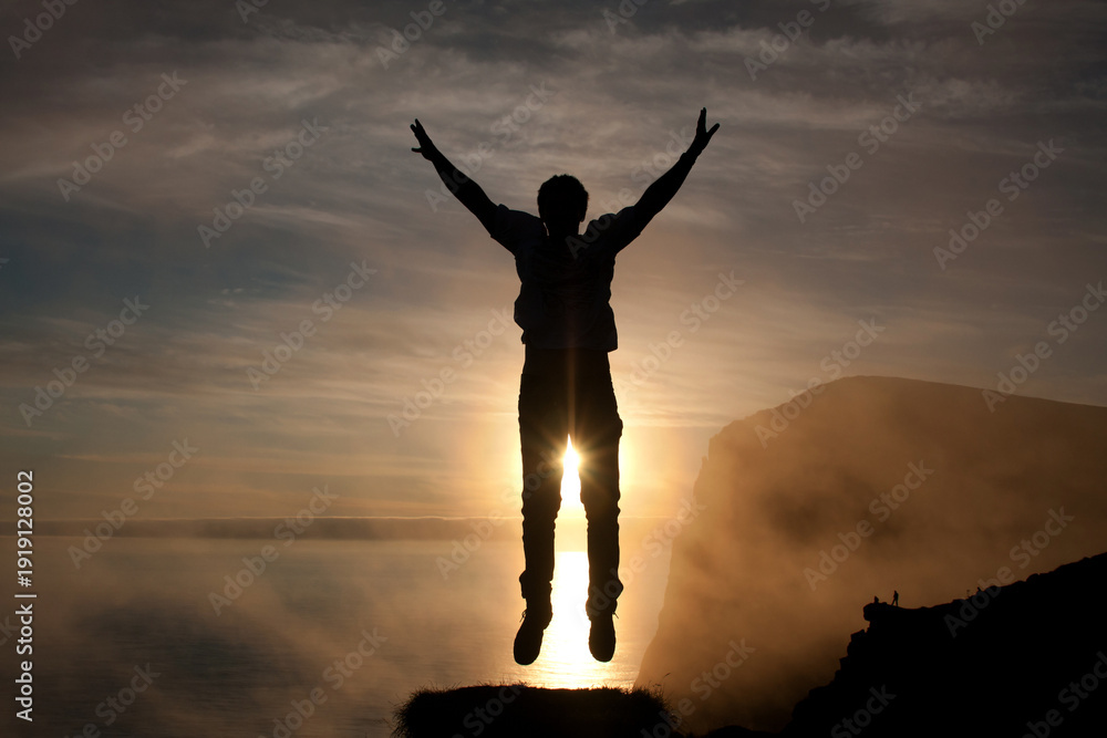 Fototapeta premium Man jumps into the air at Runde Island (Norway)