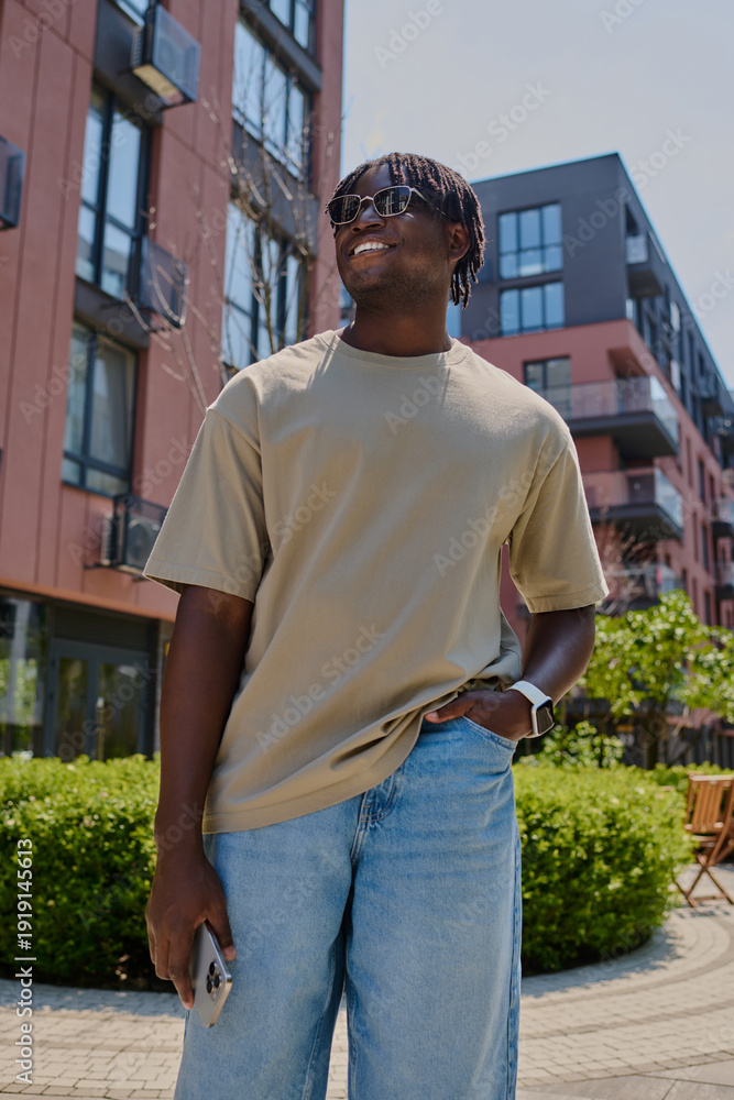 Fototapeta premium A confident young man strolls through a lively cityscape, exuding charm and style.