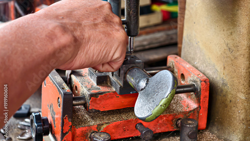 Konstfotografi Skilled hands precisely duplicating a key on a specialized duplication machine,