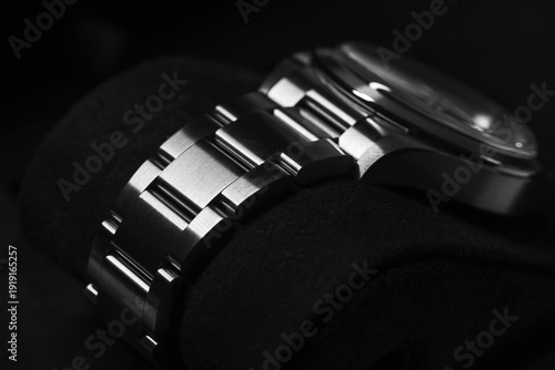 Wallpaper Mural Detailed macro shot of a metallic watch bracelet, showcasing its sleek, durable design and satin finish through contrasting light and shadow for a modern and elegant aesthetic in black and white Torontodigital.ca