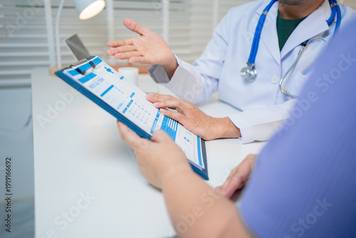 Male doctor consulting with female patient in a clinical examination room, documenting medical history, discussing symptoms, treatment plans, and prescriptions, reflecting professionalism, truste