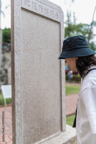Фотография Person observing ancient stone stele at chihkan tower