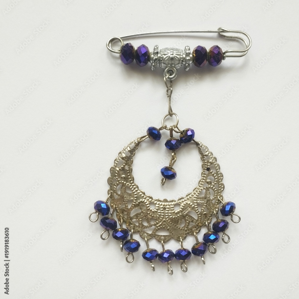 Obraz premium Creative handmade beaded safety pin ornament with purple beads