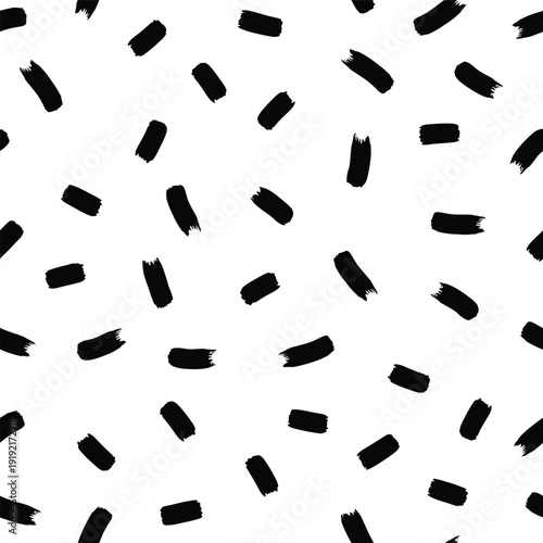 Black fragments scattered randomly on a plain surface viewed from directly above