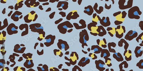 Seamless vector leopard pattern in warm brown with mustard and soft blue accents on a muted grey-blue background. Ideal for premium apparel, scarves and sophisticated lifestyle 