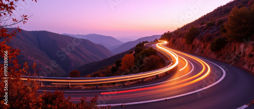 Curved road mountain sunset light trail autumn landscape twilight scenic travel serene. Curved road with light trails winds through mountain